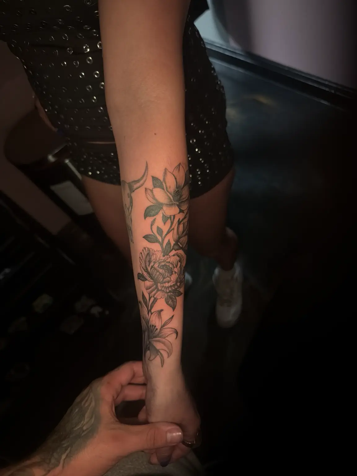 Flowing floral work wrapped along the forearm with delicate shading.