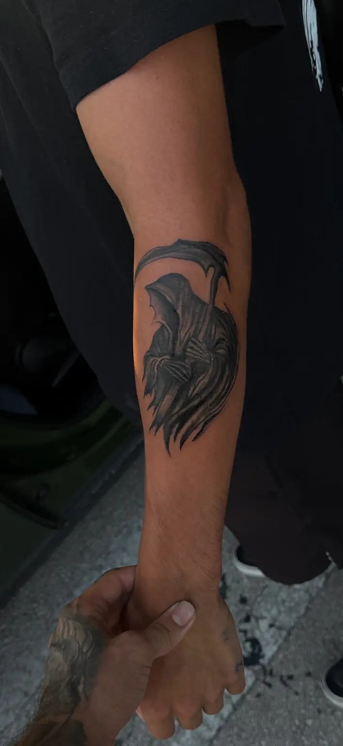 Hooded Grim Reaper holding a scythe in deep black and grey.