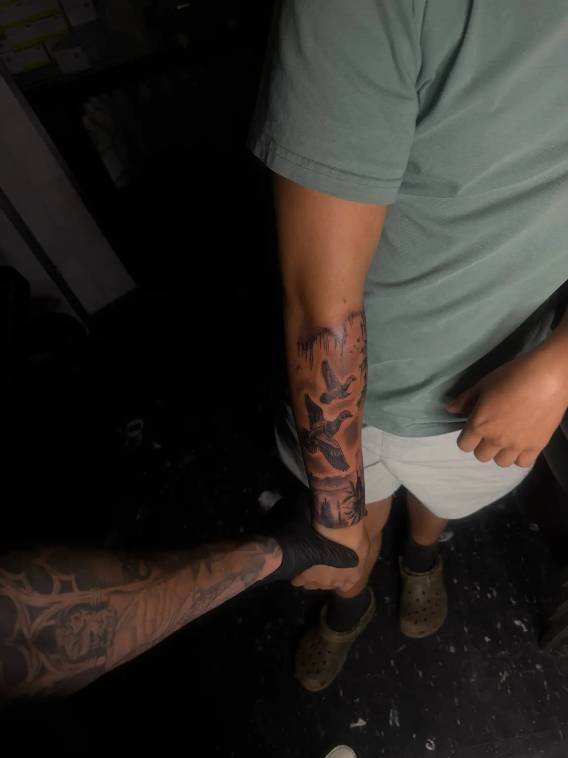 A narrative forearm piece with atmosphere, depth and soft background fades.
