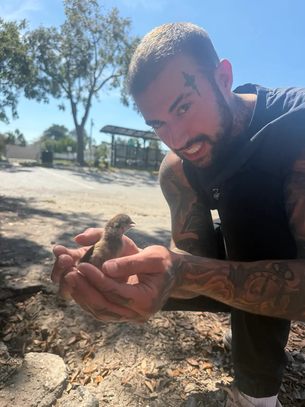 Pharaoh outdoors holding a small bird in his cupped hands
